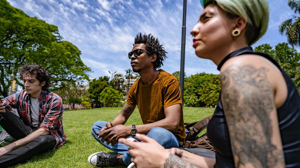 Friends sitting on grass outside