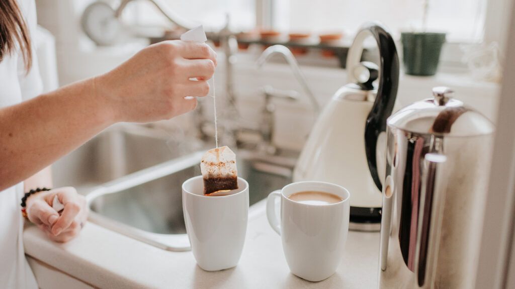 Person making a cup of tea at the kitchen sink